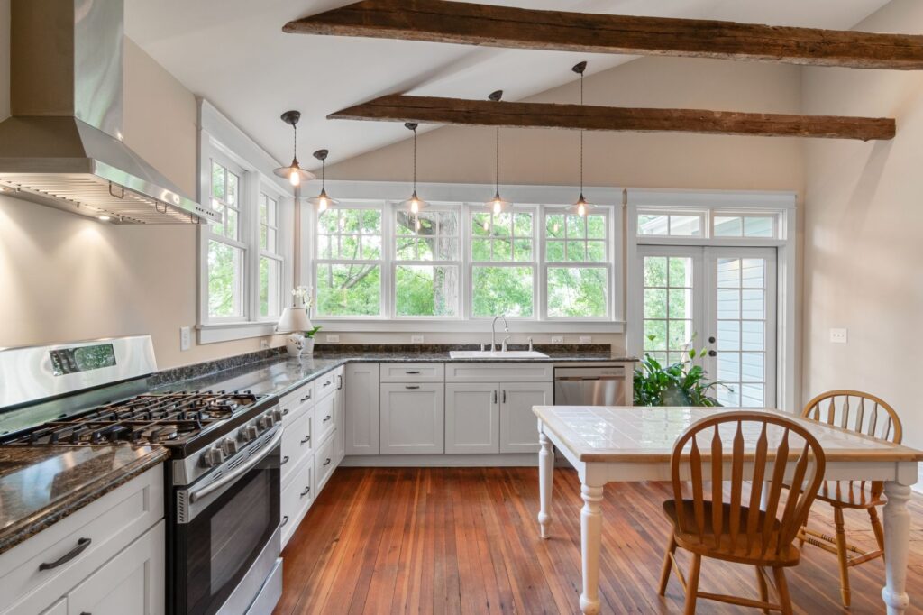 A bright renovated kitchen with white cabinets and wood floors