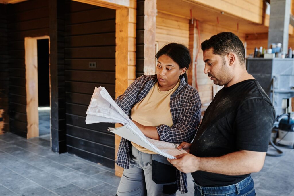 Two members of the crew reading plans together on a job site